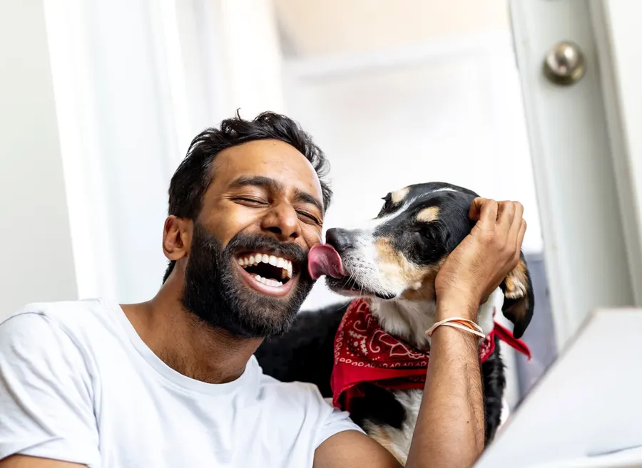 Ein lachender Mann mit seinem Hund