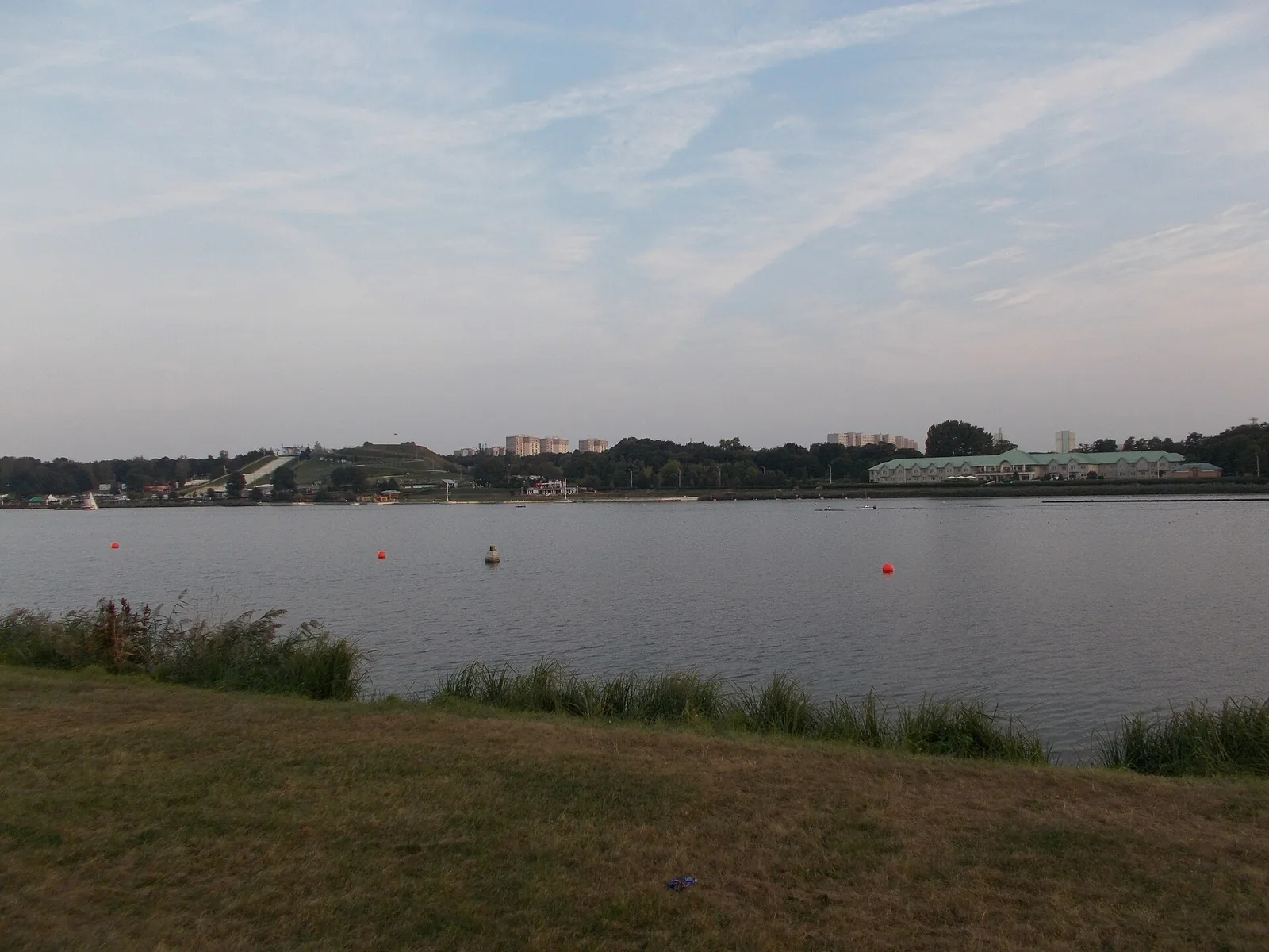 Lake Malta in Poznan - grassy bank, regatta course buoys and the city skyline behind