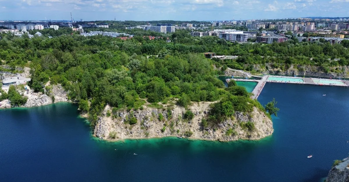 Aerial view of Zakrzowek quarry lake in Krakow with turquoise water and rock cliffs