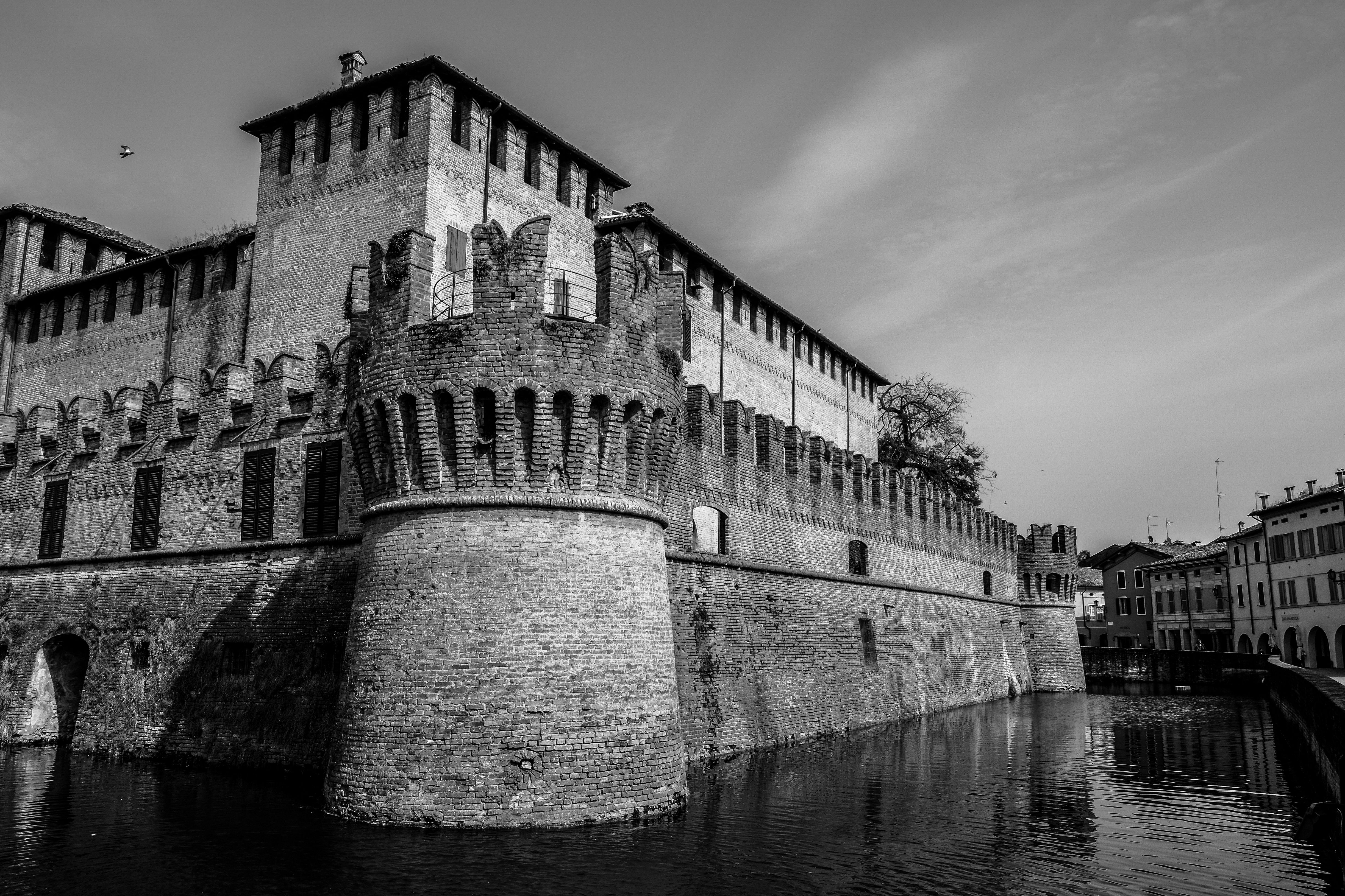 Brick walls and towers of a medieval castle beside a river, illustrating a guide to Malbork Castle